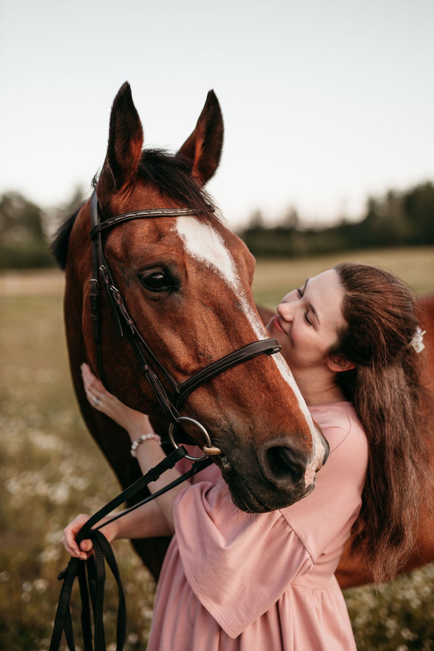 Studio Sieluisan perustaja Isabella kuvassa hevosen kanssa pellolla